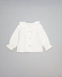 Camisa blanca de algodón estructurado con volante y entredós en delantero