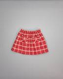 Falda roja fruncida de cuadros con bolsillos desflecados