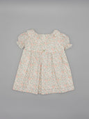 Vestido de bebé blanco con estampado floral rosa y verde, manga corta farol y cuello con encaje