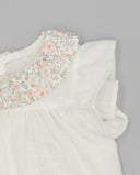 Blusa bebé niña blanca plumeti con cuello floral rosa y verde y mangas con volantes