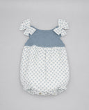 Pelele bebé niña con cuerpo de punto azul y parte inferior estampada blanca, lazos en hombros y braguita bombacho.