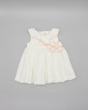 Vestido bebé niña blanco piqué sin mangas con volante cruzado y flor decorativa en coral, corte evasé