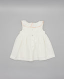 Vestido bebé niña blanco piqué sin mangas con cuello volante, ribete rosa y botones centrales
