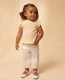 Pantalón bebé niña blanco popelín con bolsillos festoneados y zapatos merceditas blancos, conjunto verano
