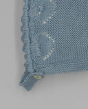 Capota bebé tricot algodón azul con calados, volante y botón, detalle punto calado artesanal color azul grisáceo