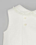 Pelele bebé blanco de piqué sin mangas con cuello bebé adornado con puntilla y botones nácar