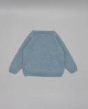 Jersey de punto tricot algodón azul celeste para bebé con mangas largas, vista trasera, fondo gris neutro.