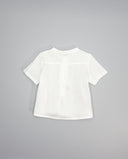 Camisa infantil blanca de lino manga corta con cuello mao, vista trasera, tejido semitransparente con pliegues