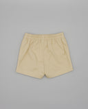 Shorts infantiles de sarga color beige con cintura elástica fruncida, corte recto y bajo rematado.