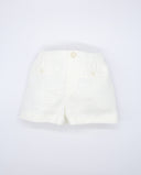 Bermuda infantil de lino color blanco roto con cintura elástica, botones decorativos y bolsillos delanteros