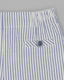 Detalle de bermuda seersucker a rayas azul y blanco con cintura elástica y bolsillo trasero con botón