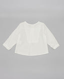 Camisa bebé blanca seersucker manga larga con canesú, corte holgado, vista trasera sobre fondo gris