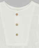 Camisa infantil blanca de seersucker con cuello redondo y tres botones de madera en el canesú delantero