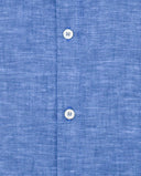 Detalle de camisa azul flameado con cuello mao y botones blancos nacarados en tejido de lino