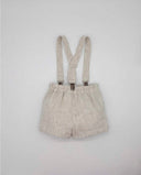 Bermuda infantil de lino rústico beige con tirantes y pinzas metálicas, cintura elástica, estilo clásico para bebé