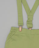 Bermuda de sarga color verde pistacho con tirantes y pinzas metálicas doradas, cintura elástica fruncida.