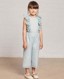 Niña con mono de gazar azul celeste con volantes en hombros y cintura elástica, largo tobillero, moda infantil verano