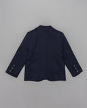 Blazer infantil azul marino vista trasera con botones en mangas, tejido estructurado y corte clásico para niño