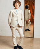 Pantalón de lino rústico beige para niño, parte de traje elegante con americana y corbata azul a rayas.