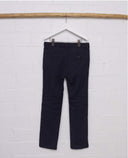 Pantalón chino niño azul marino slim fit con bolsillos traseros con botón, vista posterior en percha blanca.