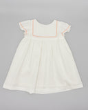 Vestido bebé niña blanco piqué manga corta con detalle ondulina rosa empolvado y canesú cuadrado