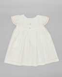 Vestido bebé niña blanco piqué con mangas volante, ribete salmón y botones en espalda