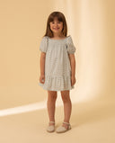 Vestido niña estampado blanco con manga farol y cuerpo elástico, con alpargatas beige, fondo crema