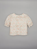 Blusa bebé niña blanca estampado floral rosa manga farol con botones, vista trasera sobre fondo gris