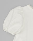 Blusa blanca piqué con manga farol abullonada y detalle de puntilla en cuello, tejido texturizado