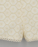 Short blanco crudo con bordado floral en relieve, detalle calado tipo guipur y remate de encaje en el bajo