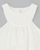 Vestido de bebé blanco sin mangas en tejido piqué con cuello redondo y corte imperio, fondo gris