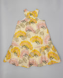 Vestido niña sin mangas estampado floral amarillo, rosa y beige con plantas grandes, corte trapecio y volante bajo.