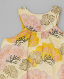 Vestido infantil sin mangas color crema con estampado floral grande en tonos rosa, amarillo y beige, escote redondo y volante