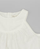 Blusa de lino blanca sin mangas con hombros caídos y pliegues frontales, marca Fina, fondo gris