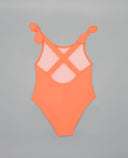 Bañador entero niña color naranja con tirantes cruzados en la espalda y nudos decorativos en los hombros