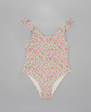 Bañador entero de niña con estampado floral de rosas en rosa y verde, tirantes con lazo, fondo gris.